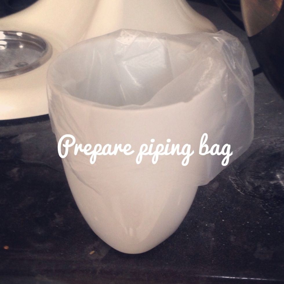 Prepare your piping bag, use a mug and fold it over the top so it's easy to add the mixture! Use a large round nozzle.