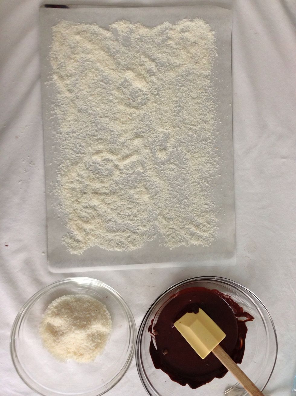 Prepare your tray with parchment paper generously sprinkled with coconut flakes. Keep some to sprinkle at the top after the trifles are dipped in chocolate yum yum