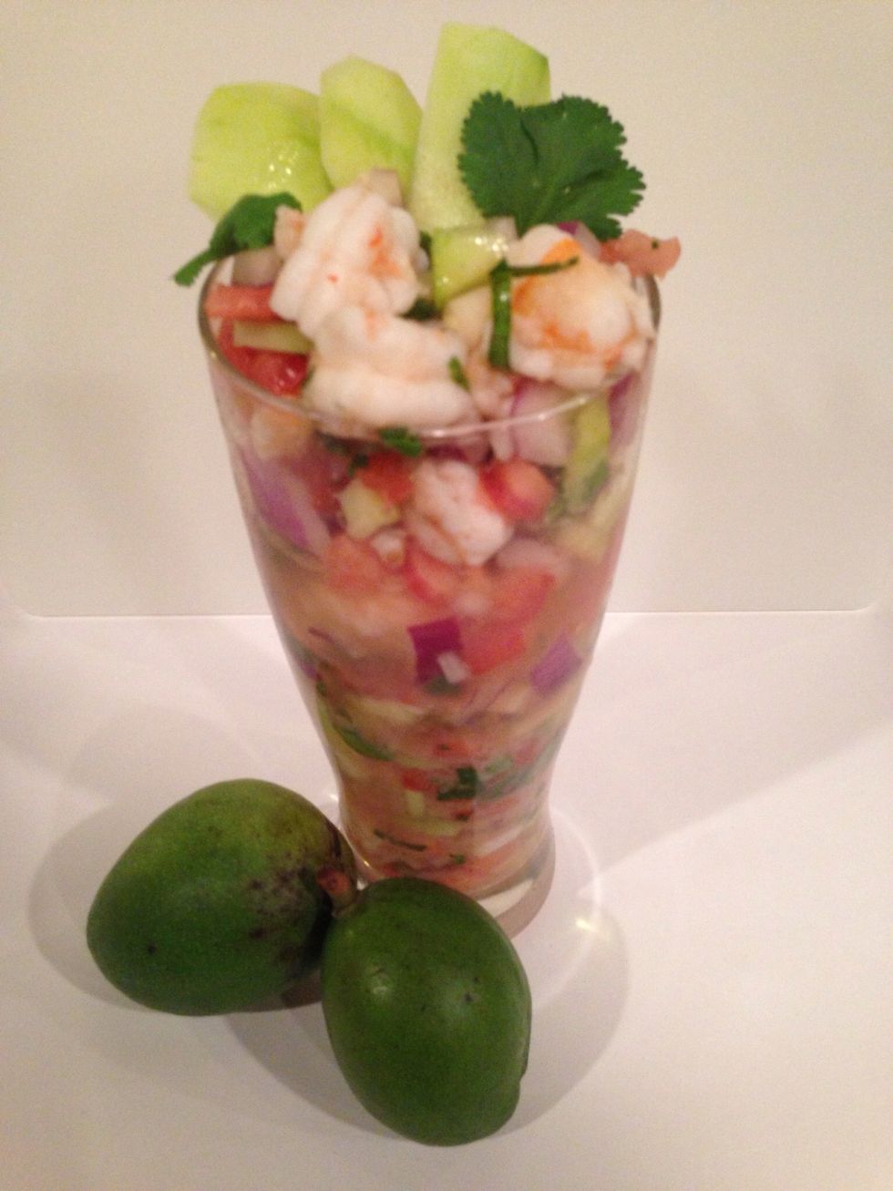 Preparing the cocktail for serving. Add the cocktail mix to a glass. Then ladle the cold shrimp broth in to the glass. Note: the more you sift the water clearer it gets. Important for presentation.