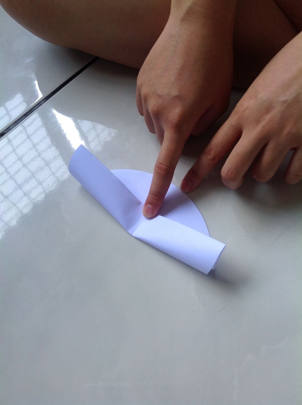 Press down the middle of the paper as shown by the index finger