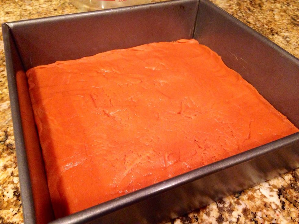 Press it into the prepared pan using a spoon, as it is quite hot. Place it in the freezer for a few minutes until it cools down.