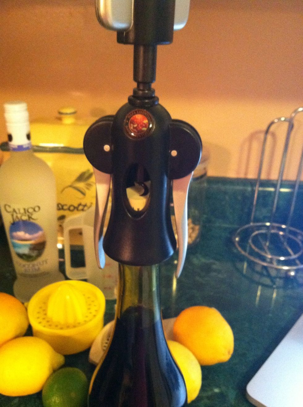 Press the arms down to pull the cork to the top of the bottle