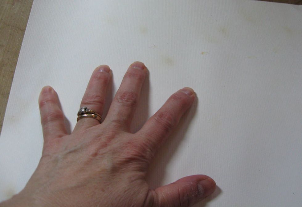 Press the INKED and EMBOSSED side of the watercolor paper into the puddles of ink.  Do not move the paper around.  Just press in place, and lightly burnish the back of the paper with your hand.