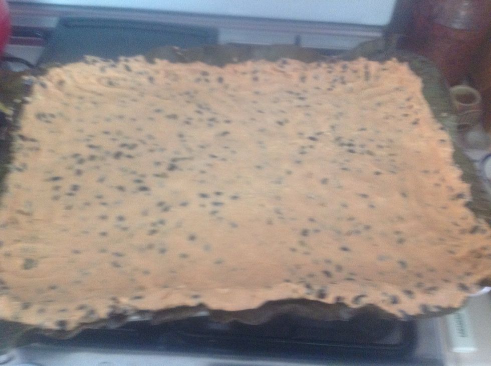 Press the masa with espel\u00f3n into the baking sheet, trying to do it as evenly as possible. Make a rim around the sheet with the masa.