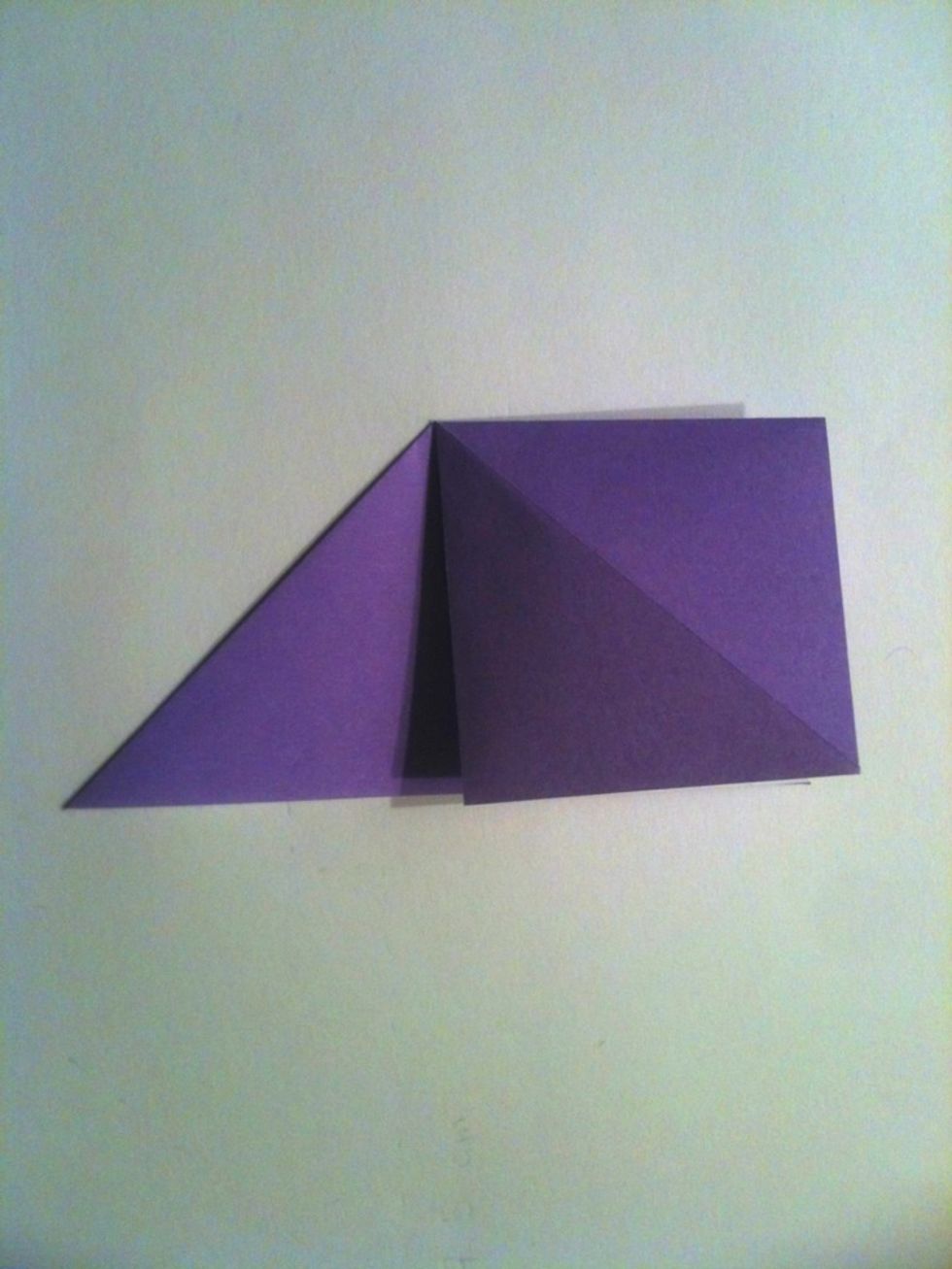 Press the opened flap of paper down and match the corners together.