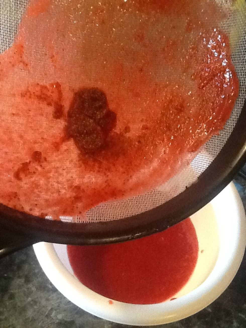 Press the pur\u00e9e through the sieve. What is left behind is the seeds. Discard this. Let the puree cool completely before pouring over the strawberries