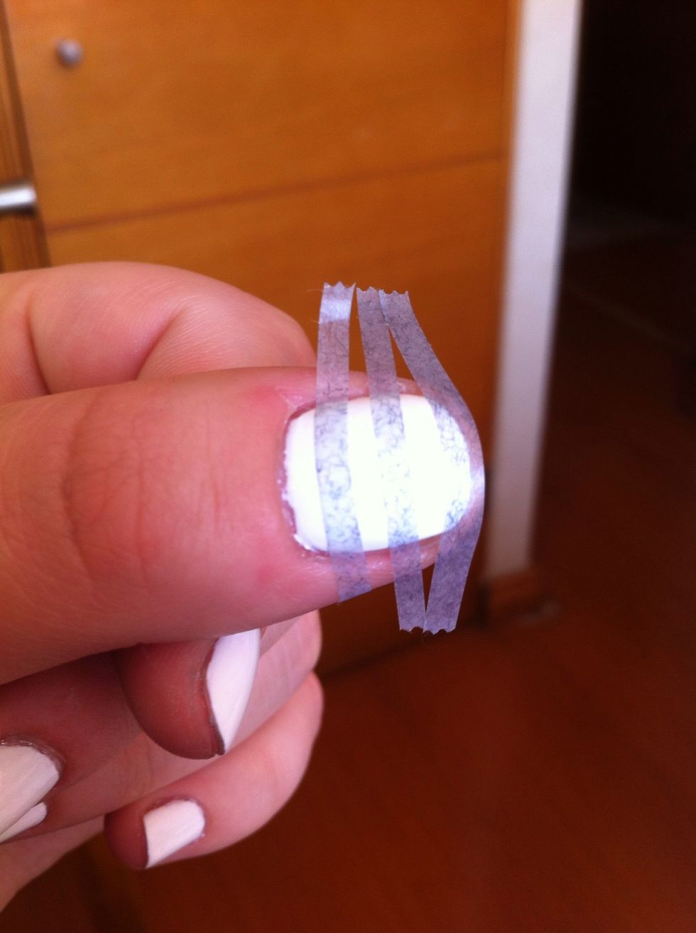Press the scotch against your clothes so the glue wears out, that way your white nail polish won't be removed. Cut stripes and place them on your nails, press really well on the edges of each nail.