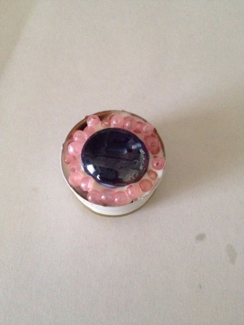 Press the smaller beads into the glue surrounding the larger gem like this!