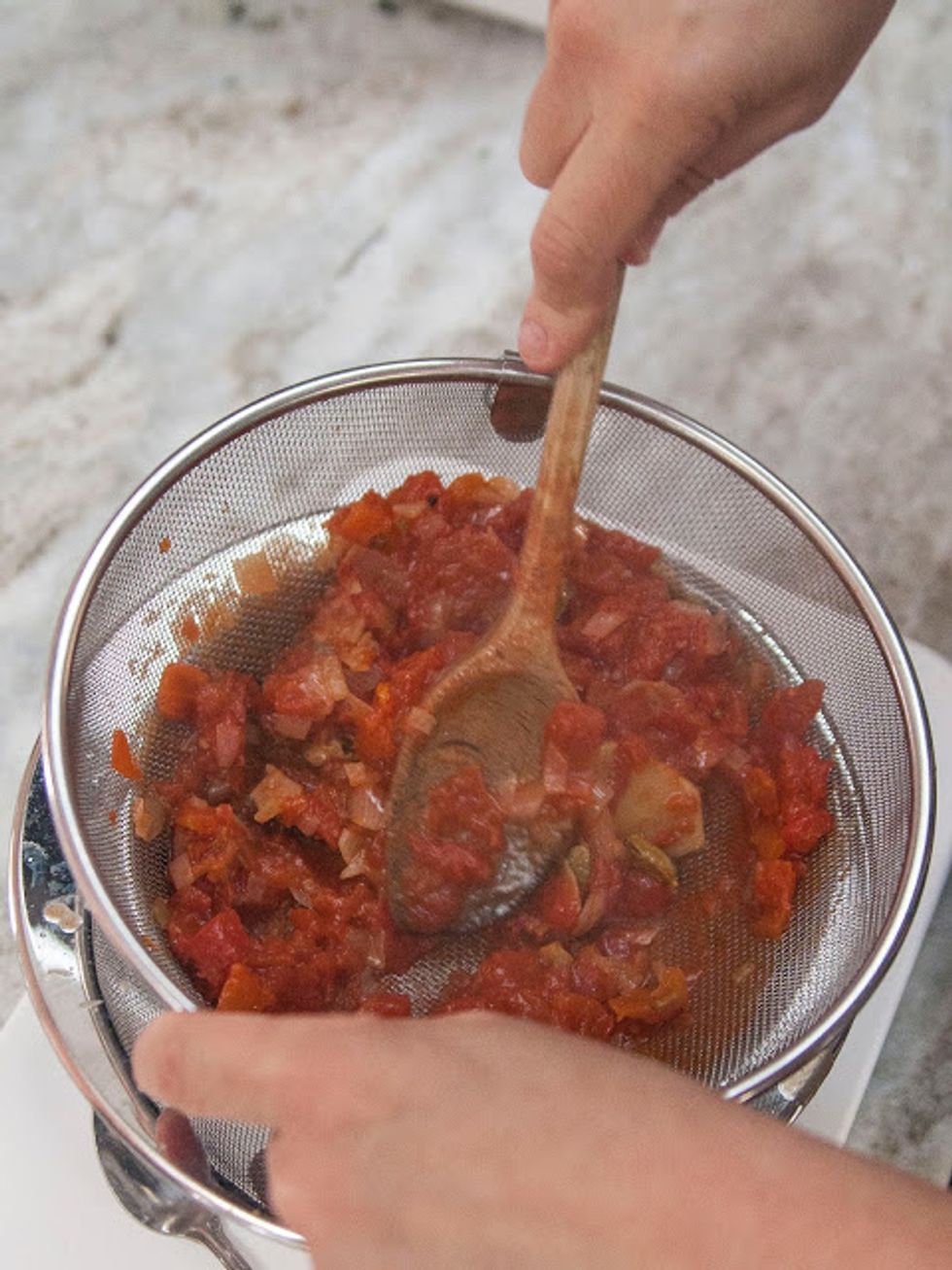 Press the tomato sauce through the mesh leaving the pulp and the whole spices behind.