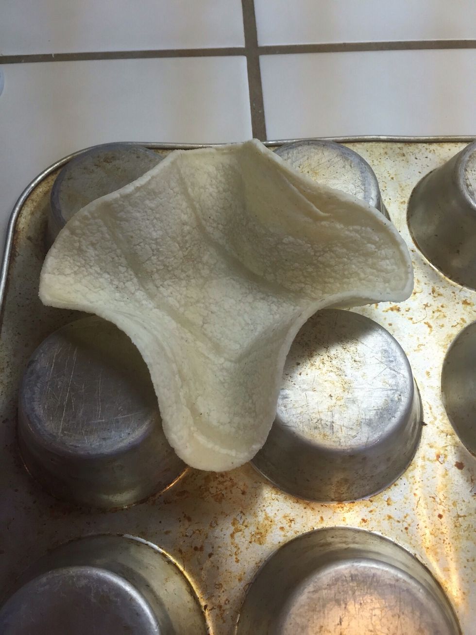 Press tortillas down between the tins to give it a flat bottom.