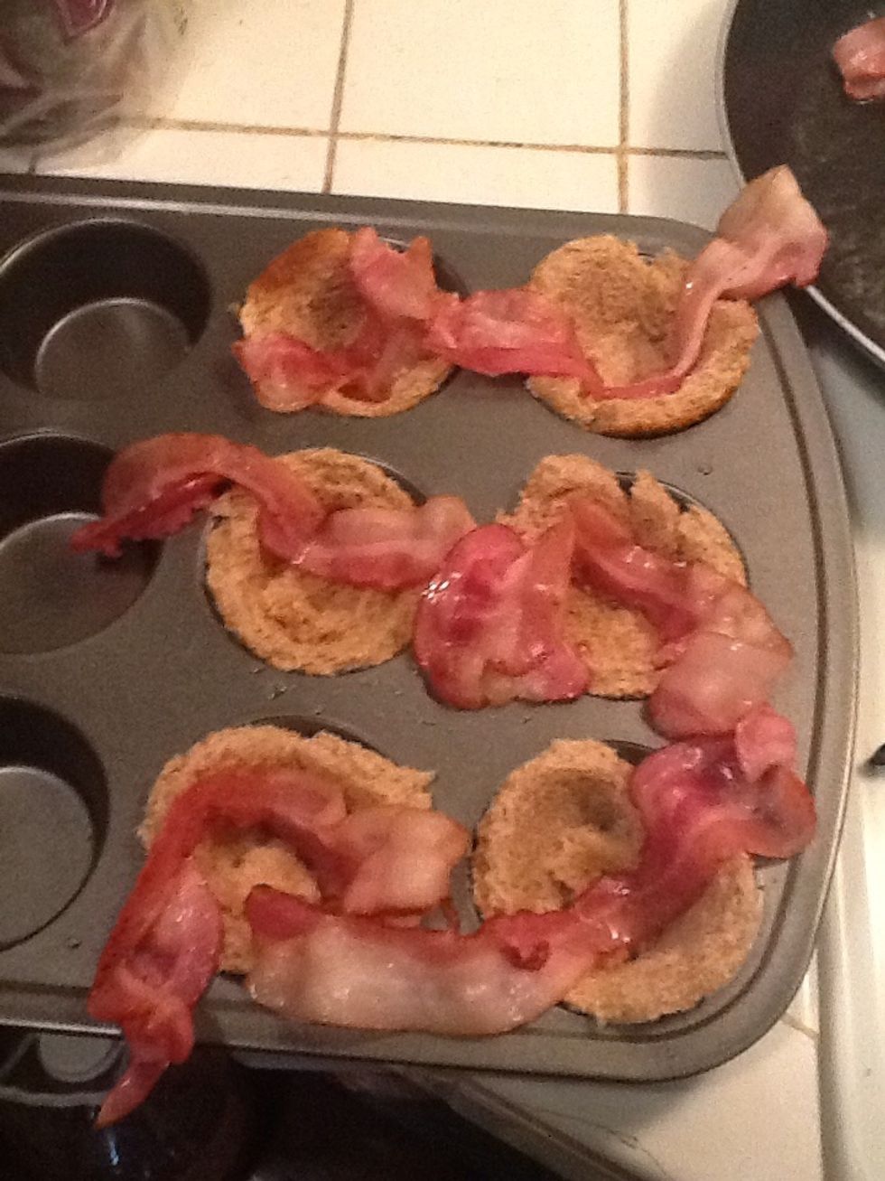 Press two halves into cups and patch gaps with the extra bread. Lay bacon slices into each cup.