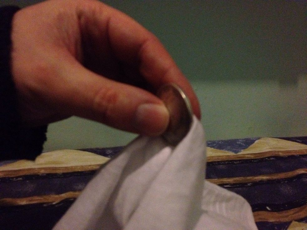 Pretend to pull the coin through the material.