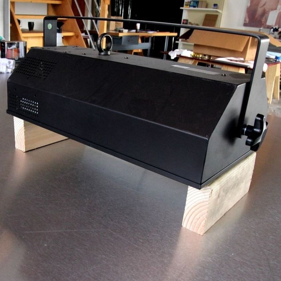 Prop up the light so you can place your project below. It doesn't need to be fancy- we used wood blocks we had on hand. Be sure that you work on a surface that can withstand the heat of the light!