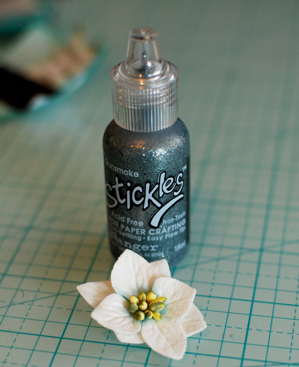 Pull a white flower from the Petaloo Blossoms pack. With the Silver Stickles Glitter, cover the yellow flower center.