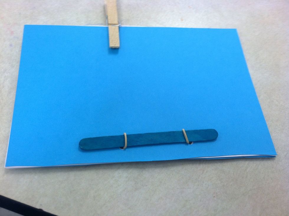 Pull band tight on back cover. Stretch the band non back cover. Slip the band through the empty hole. Slide the popsicle stick through new band loop on cover.