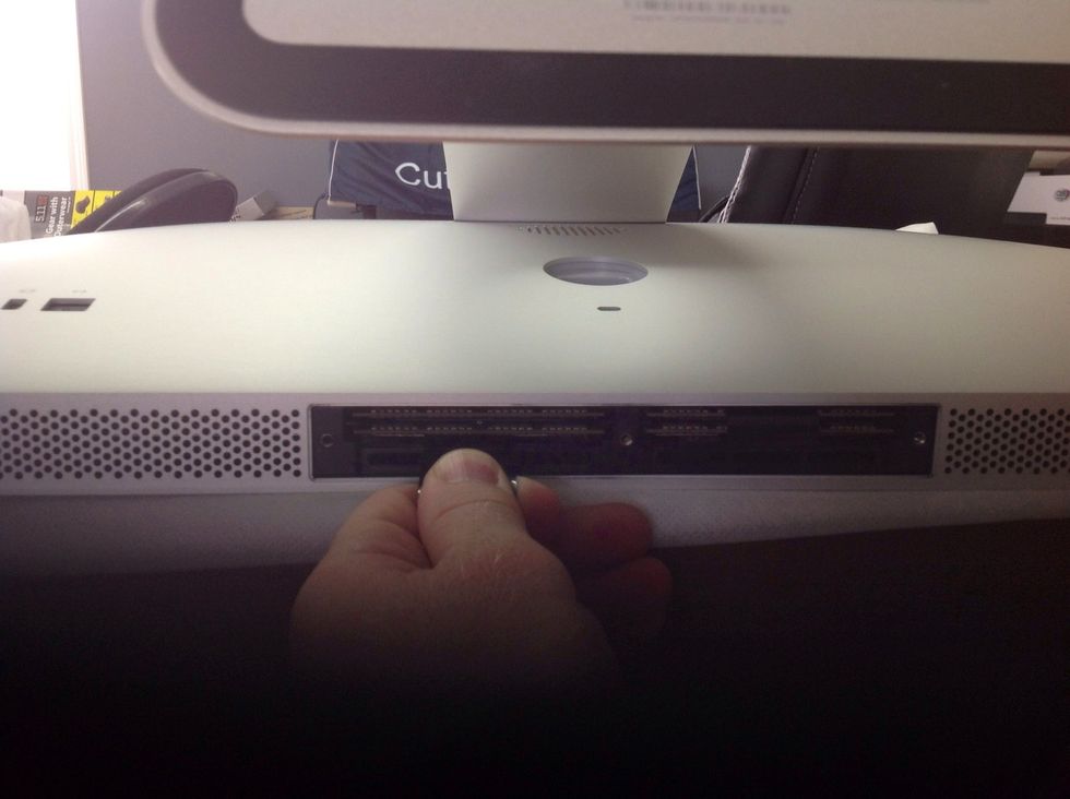 Pull black plastic strip out carefully (it is tucked in at top). Pull outward with steady pressure until the memory card(s) pops out a little.