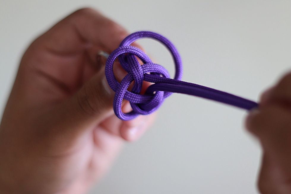 Pull both the bottom and the top double strands apart gently to help tighten and to help move the string into place. Like so in the picture above.