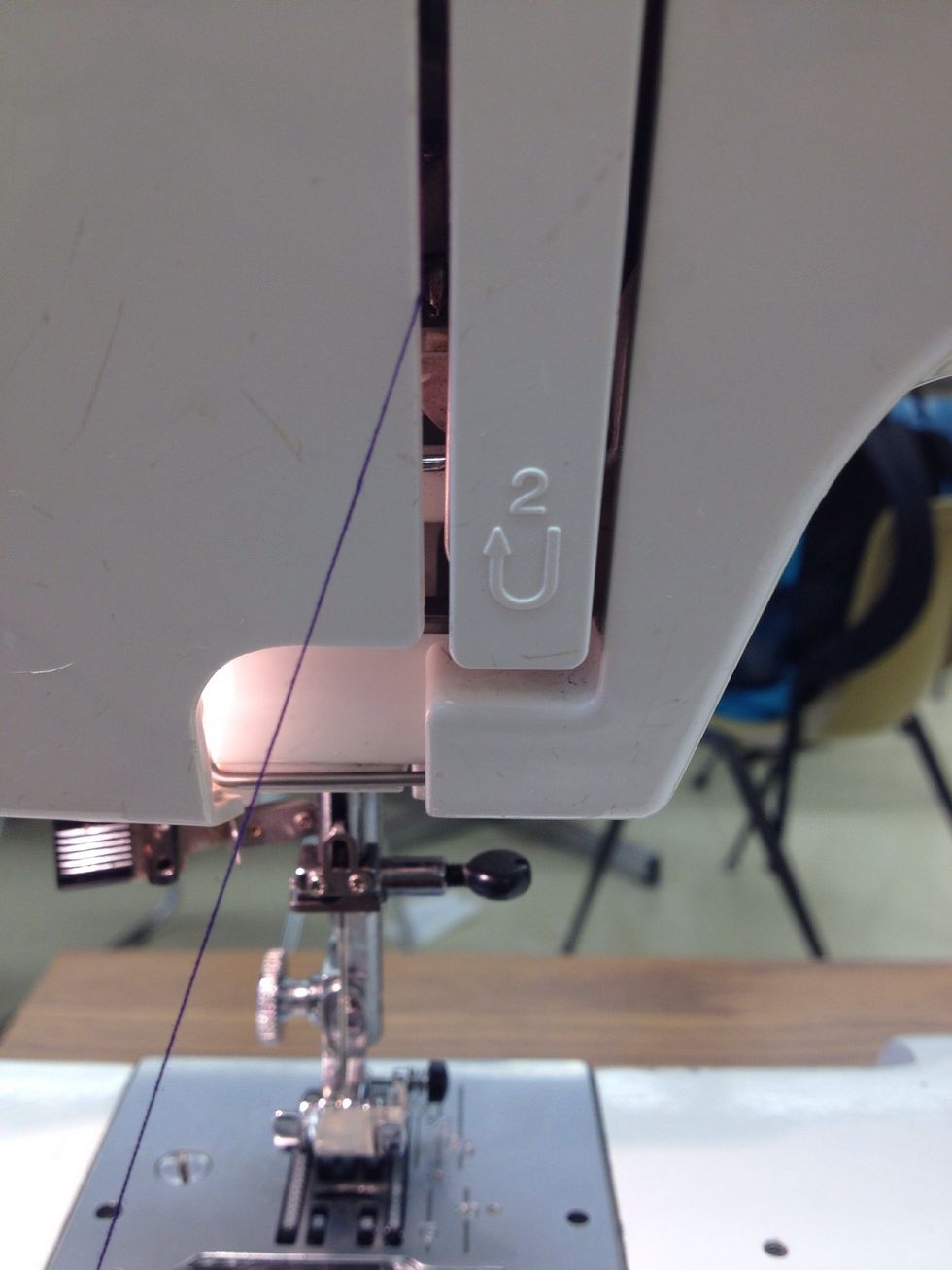 Pull down along the left side of the thread guide plate.
