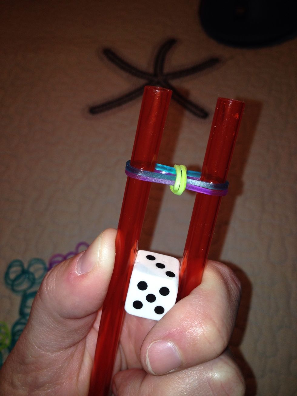 Pull first elastic over second and third elastics and over straw ends toward the center.