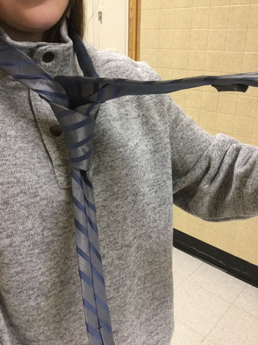 Pull it through so it forms a triangle at the base of the knot.