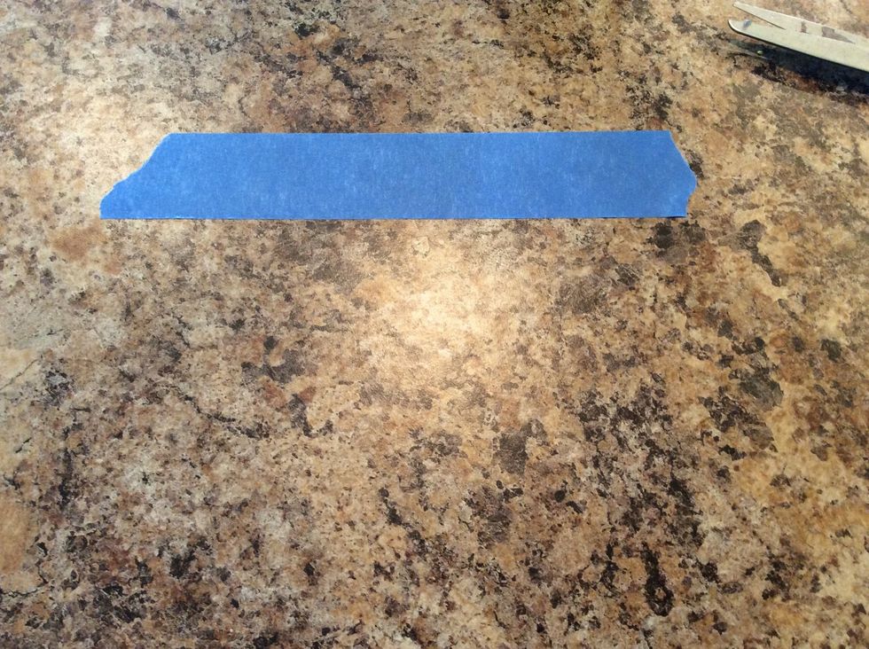 Pull off several strips of painters tape and lightly stick them on the counter or table