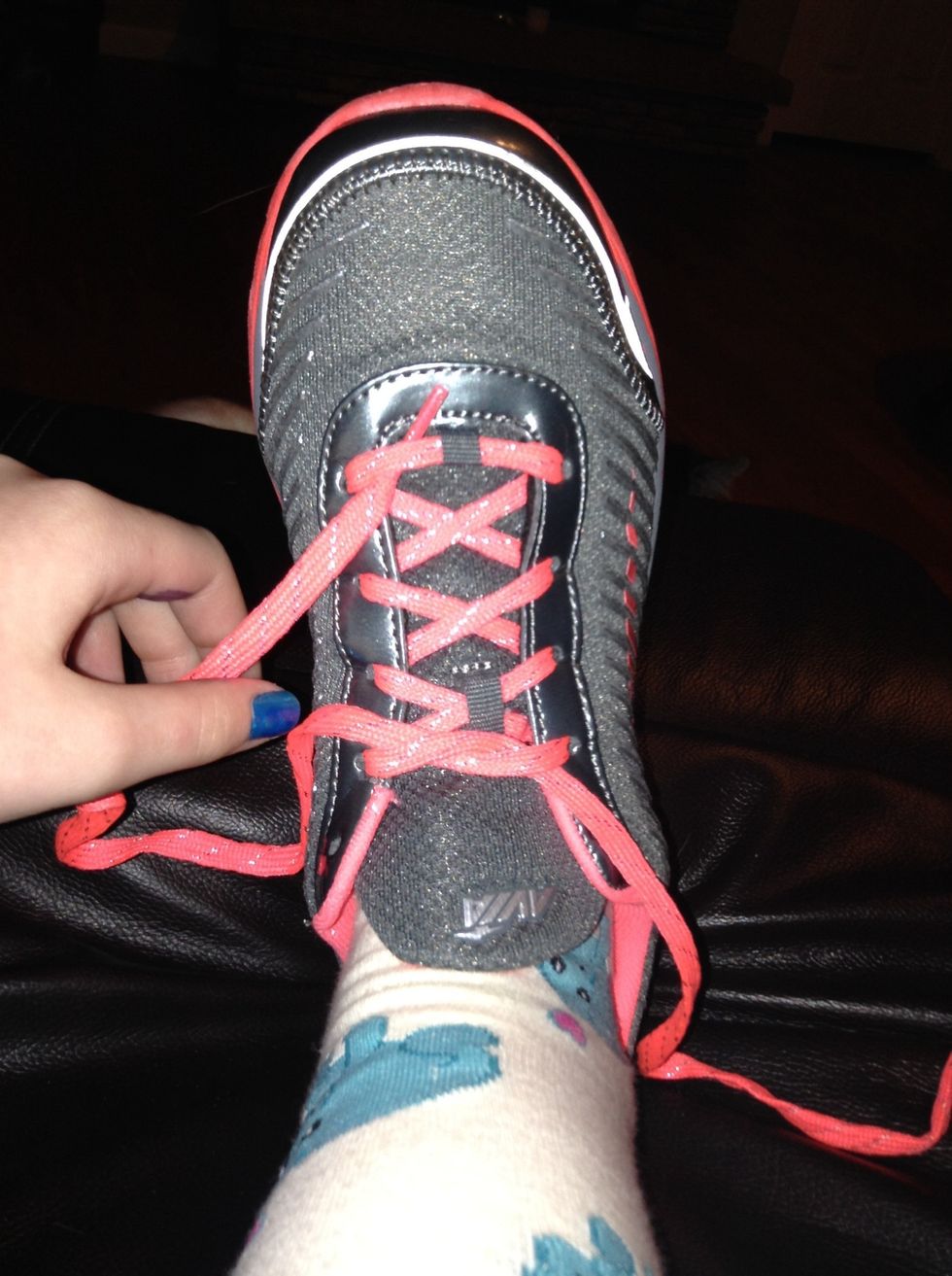 Pull one of the laces through the other