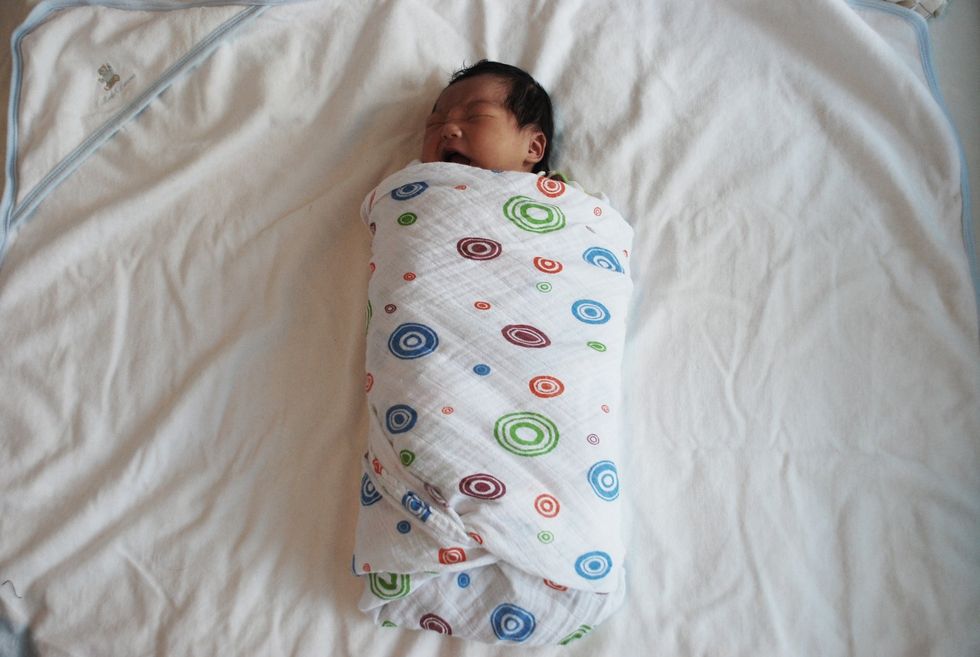 Pull remaining side of blanket across the baby's chest. Tuck underneath. Swaddled properly, you will have a happy baby.