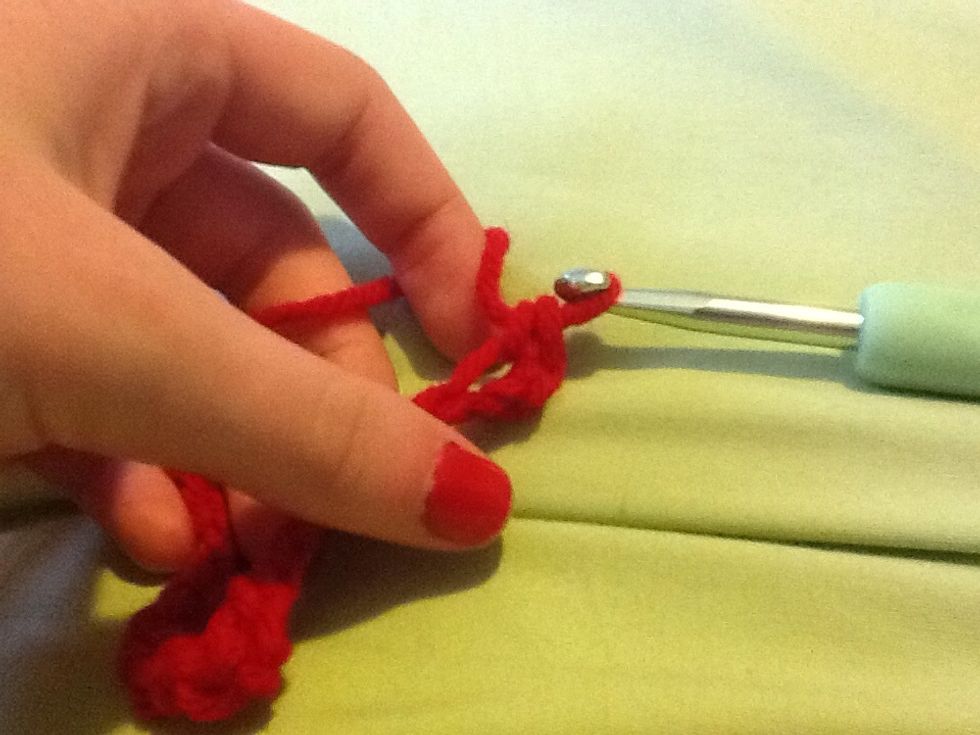 Pull the 2 bottom loops over the wrapped around yarn