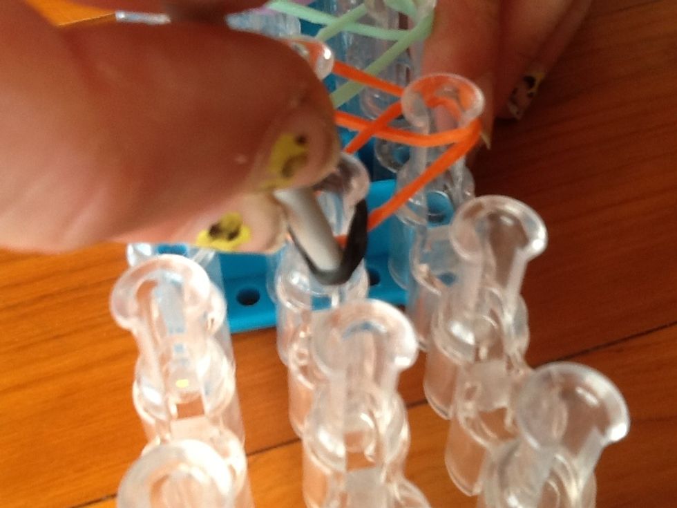 Pull the black band back and get the orange band and pull it over like this.