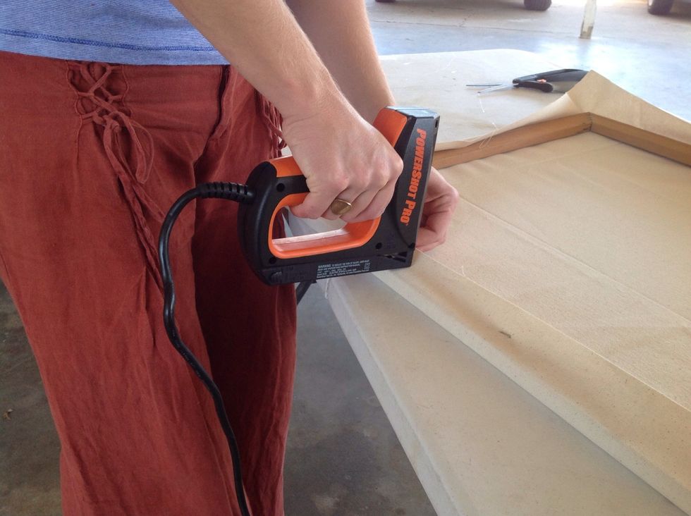 Pull the canvas away from the last staple and inward as you staple so there will be minimal wrinkles. Do this about 3 inches from both sides of the center staple then repeat on opposite side of frame.