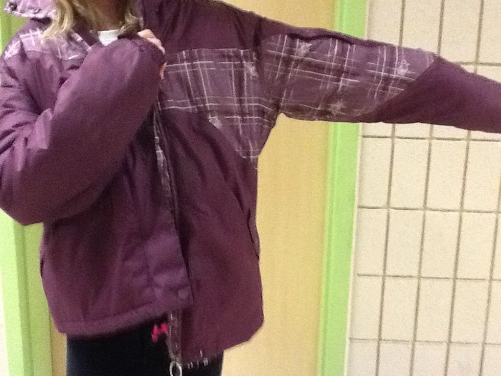 Pull the coat towards you and push your arm through.
