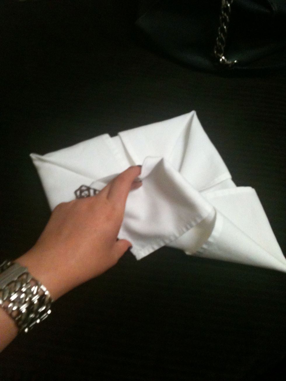 Pull the corner piece from the bottom and pull it out, making the napkin form a leaf shape on the corner. And continue the same steps for all corners.
