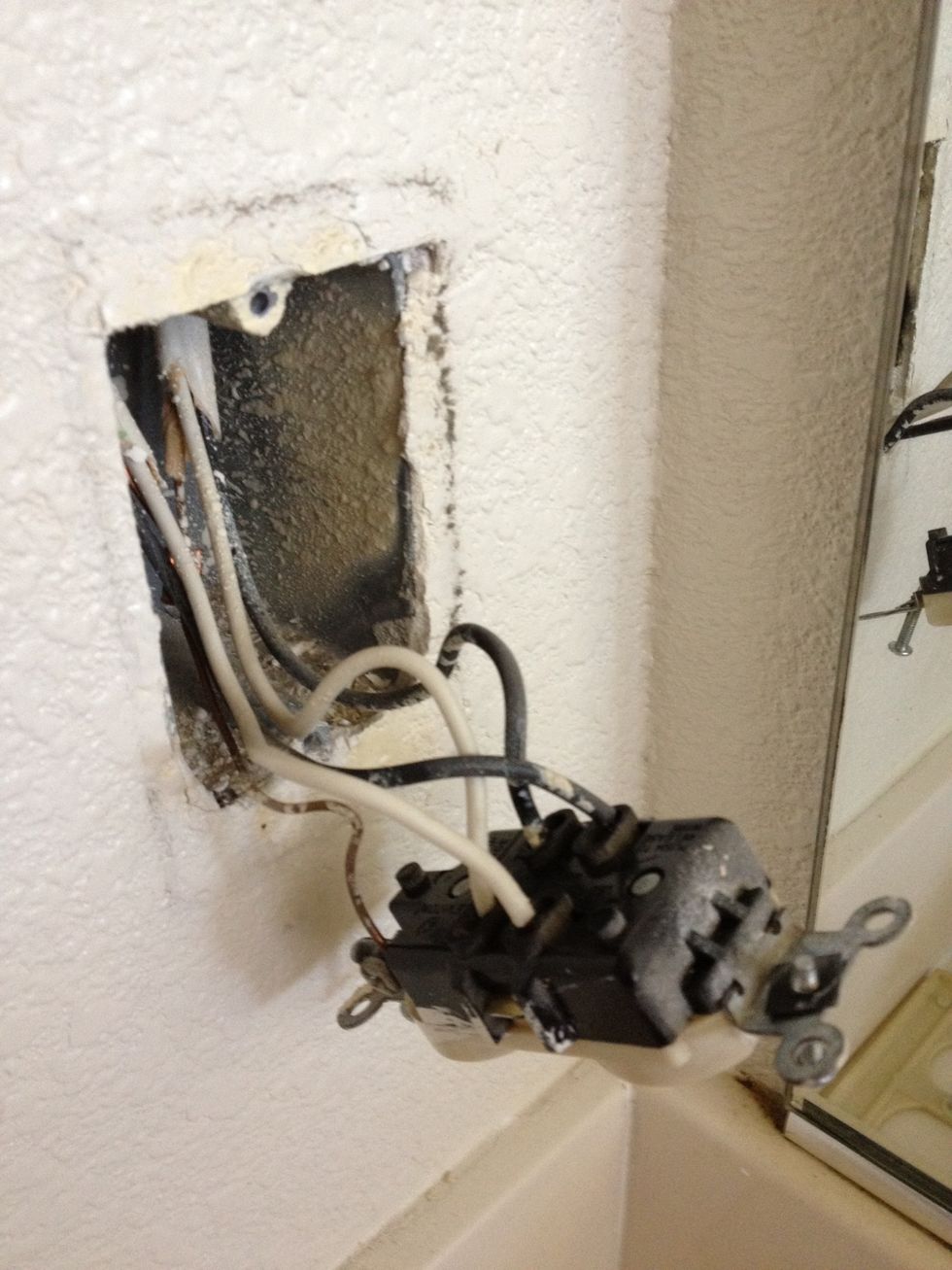 Pull the entire outlet away from the J-box to reveal the backside where the wires are. This specific plug's J-box has 5 wires: 2 black, 2 white, and 1 bare copper ground wire.