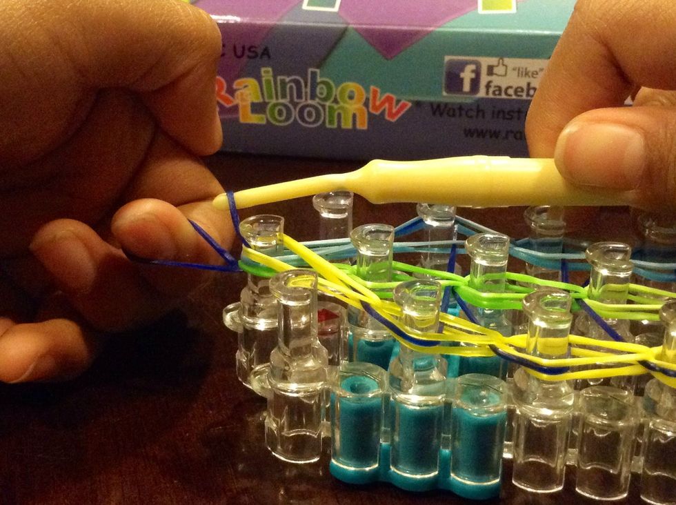 Pull the hook through the rubber bands and out with the rubber band still on the hook