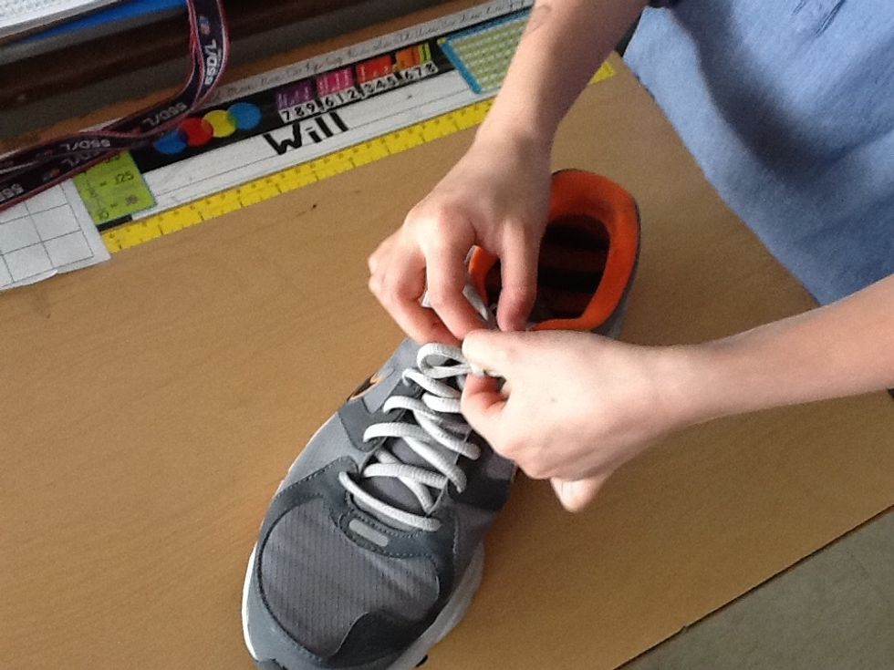 Pull the left lace through the hole and tighten.