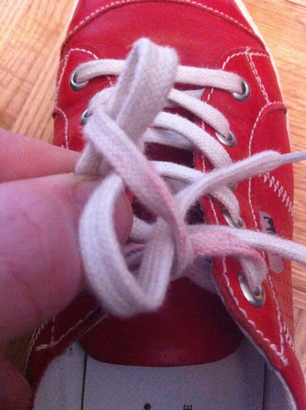 Pull the loose-end lace through the hole and pull to tighten