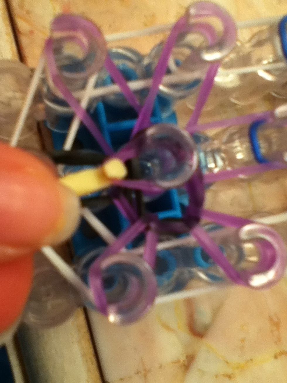 Pull the middle purple band ( the one that matches the purple band on the other peg) and pull it over. Do this for all the other bands.