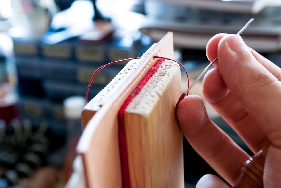 Pull the needle through first hole and line up the thread in the centre (same length on both sides). Note: I'll refer to the needle in your right hand as needle 2 and in your left hand as needle 1