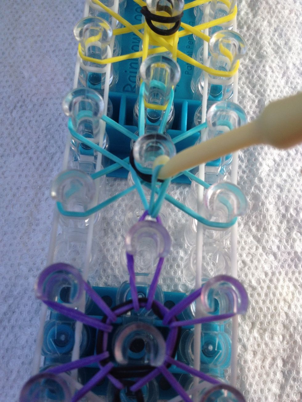 Pull the next rubber band over the middle peg of the next starburst. Hook all the starbursts counterclockwise until you get to the top.