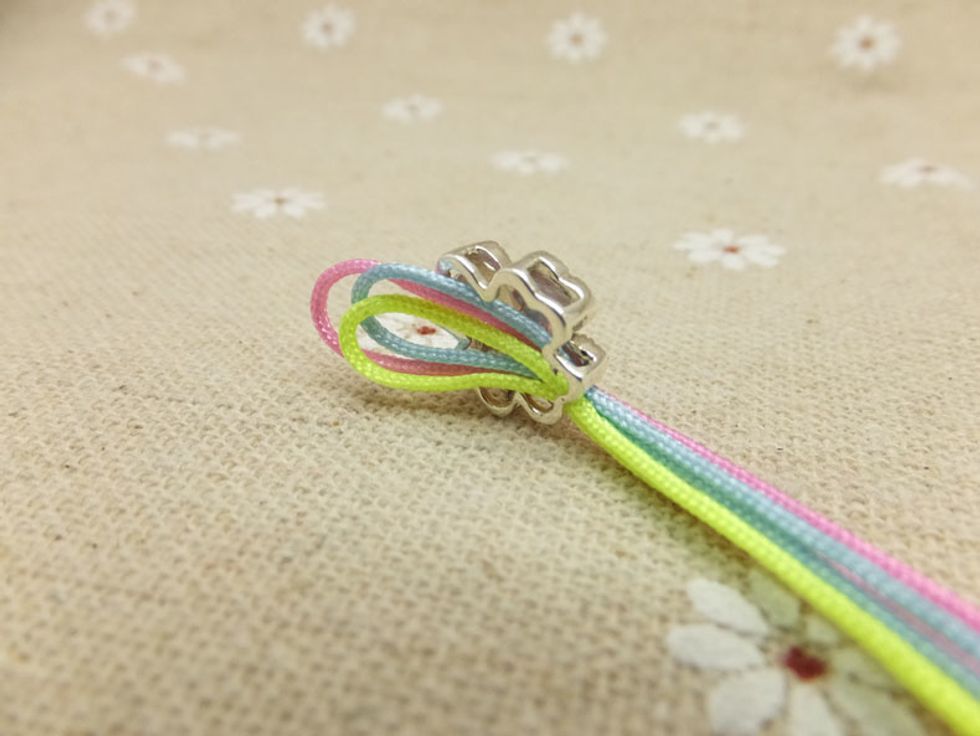 Pull the other two cords through the hole of bead. Then pull the three cords through the loop. (As shown in the picture)