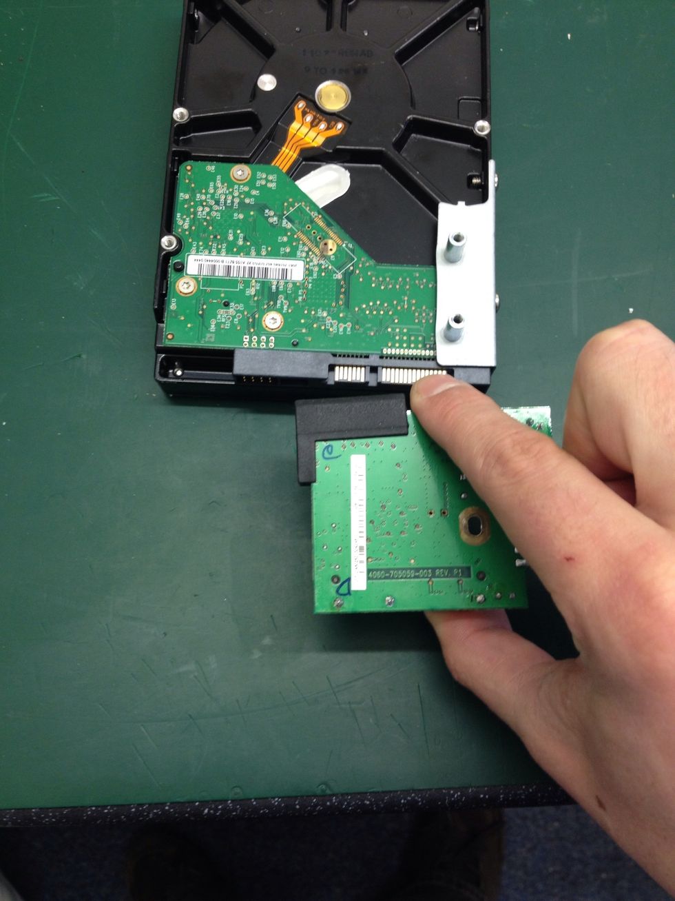 Pull the PCB away from the drive, sliding it NOT lifting!