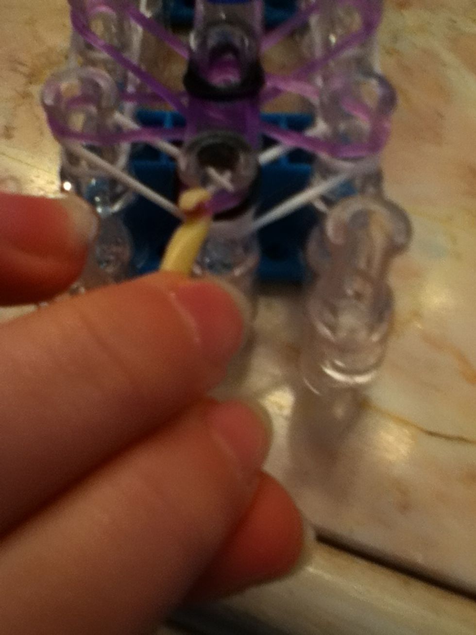 Pull the purple rubber band over the peg
