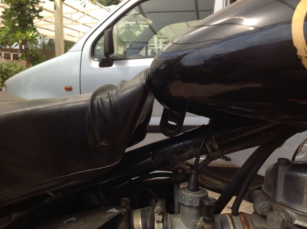 Pull the seat cushion back and press the fuel tank down