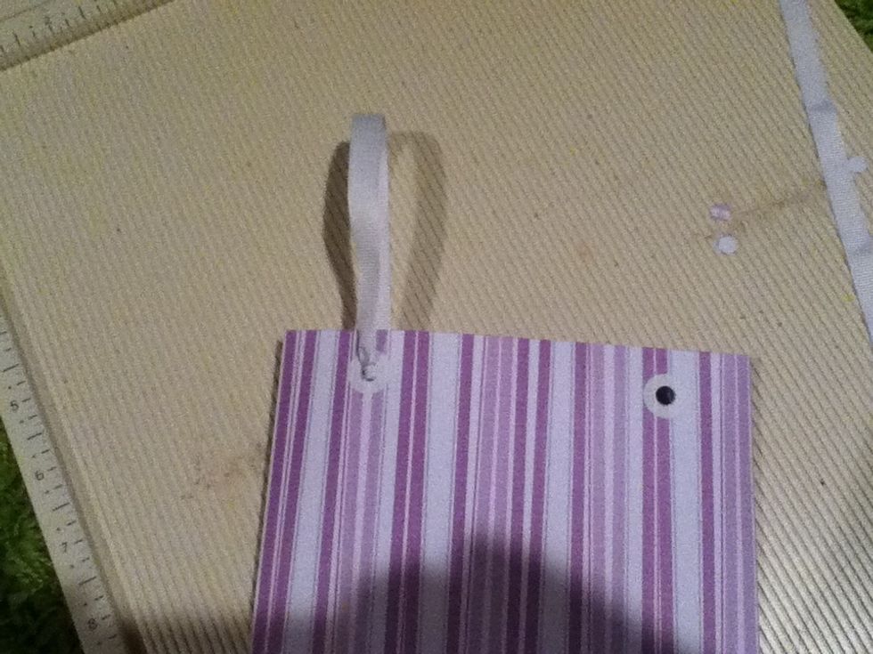 Pull the string so that the knot is flush with the paper, and repeat with the other end. Be sure to thread from the outside in.