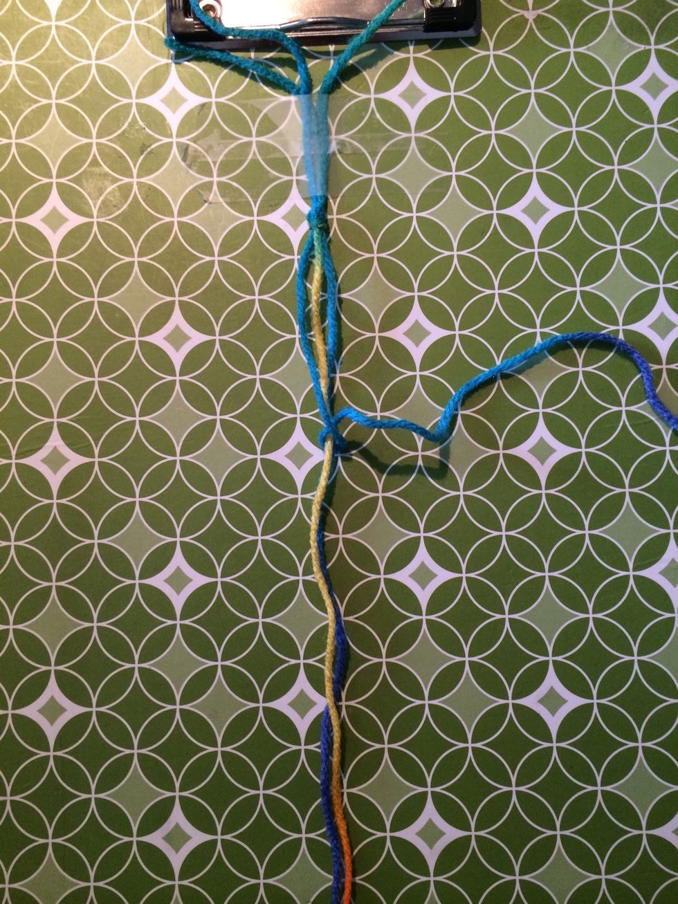 Pull the string through and this will cause it to wrap around the other strings.