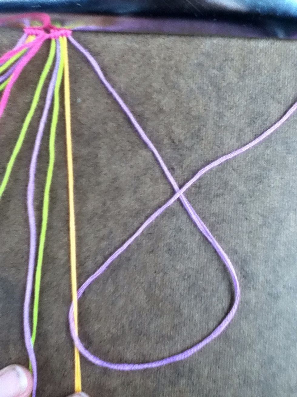 Pull the string under the base string (orange in this case), over and up.