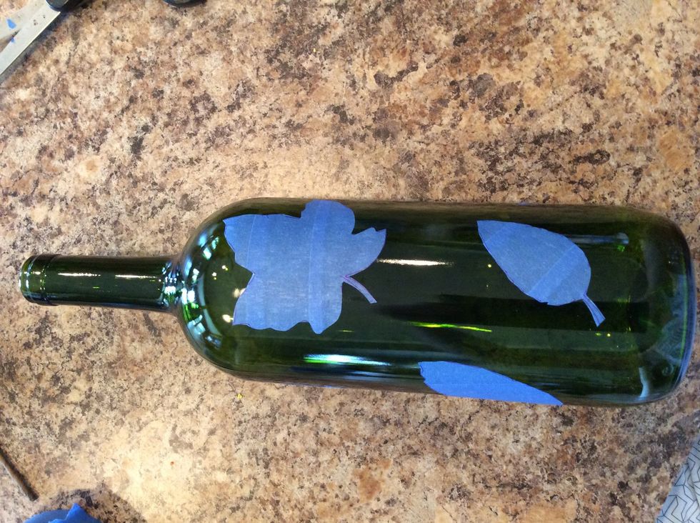 Pull the tape off the counter, being careful to keep the strips together and cut out your leaves. Place them on your bottle. I place mine randomly and use different shapes and sizes