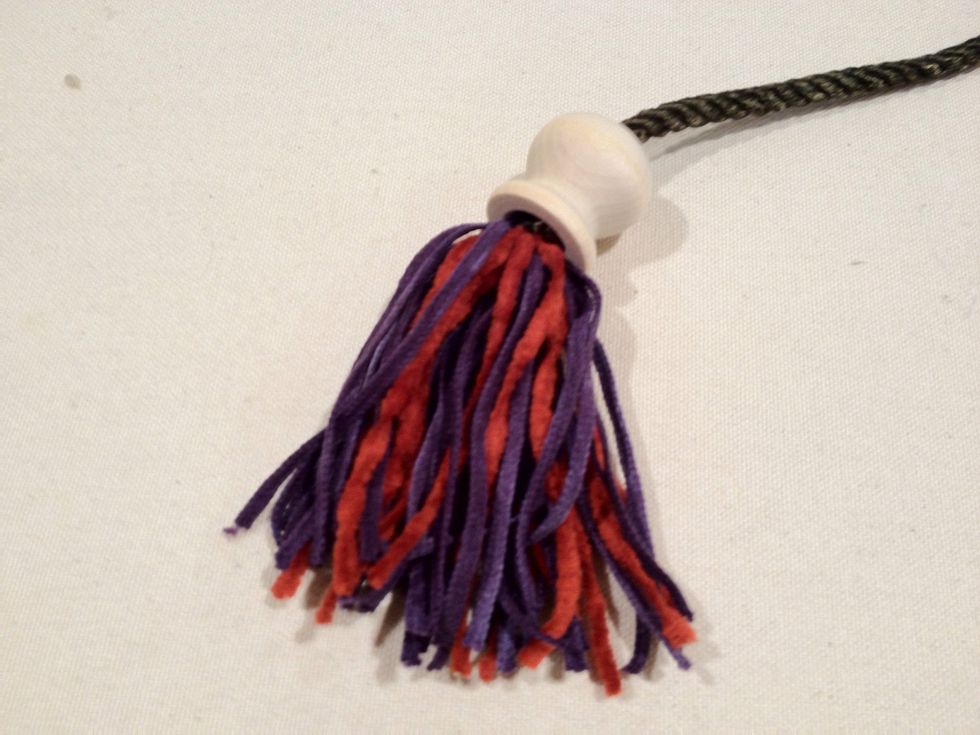 Pull the tassel form over the knot. Repeat the process for the other end of the cord.