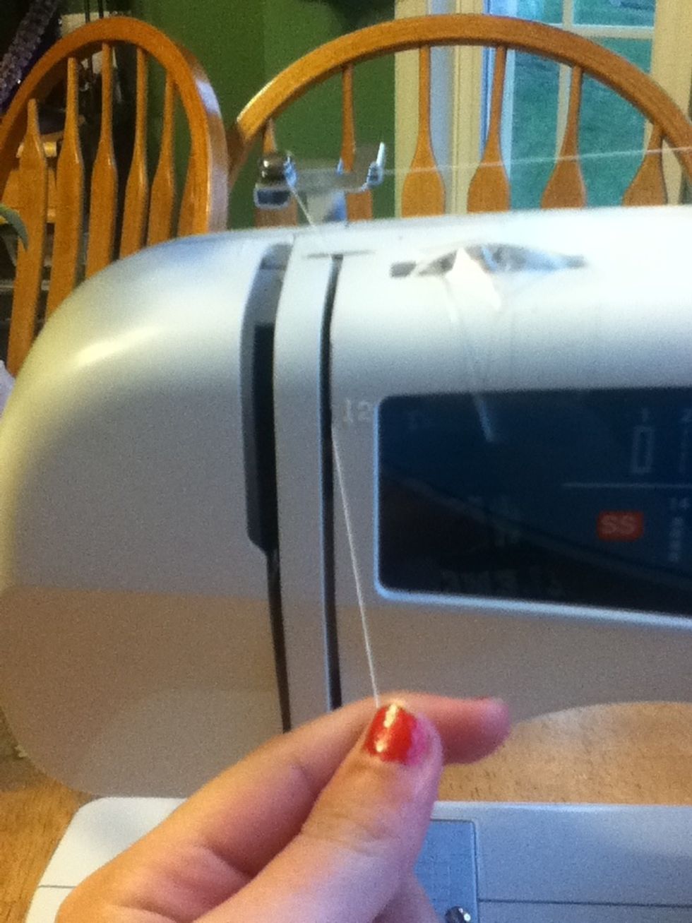 Pull the thread down into the slide. This is the the opening to the right.