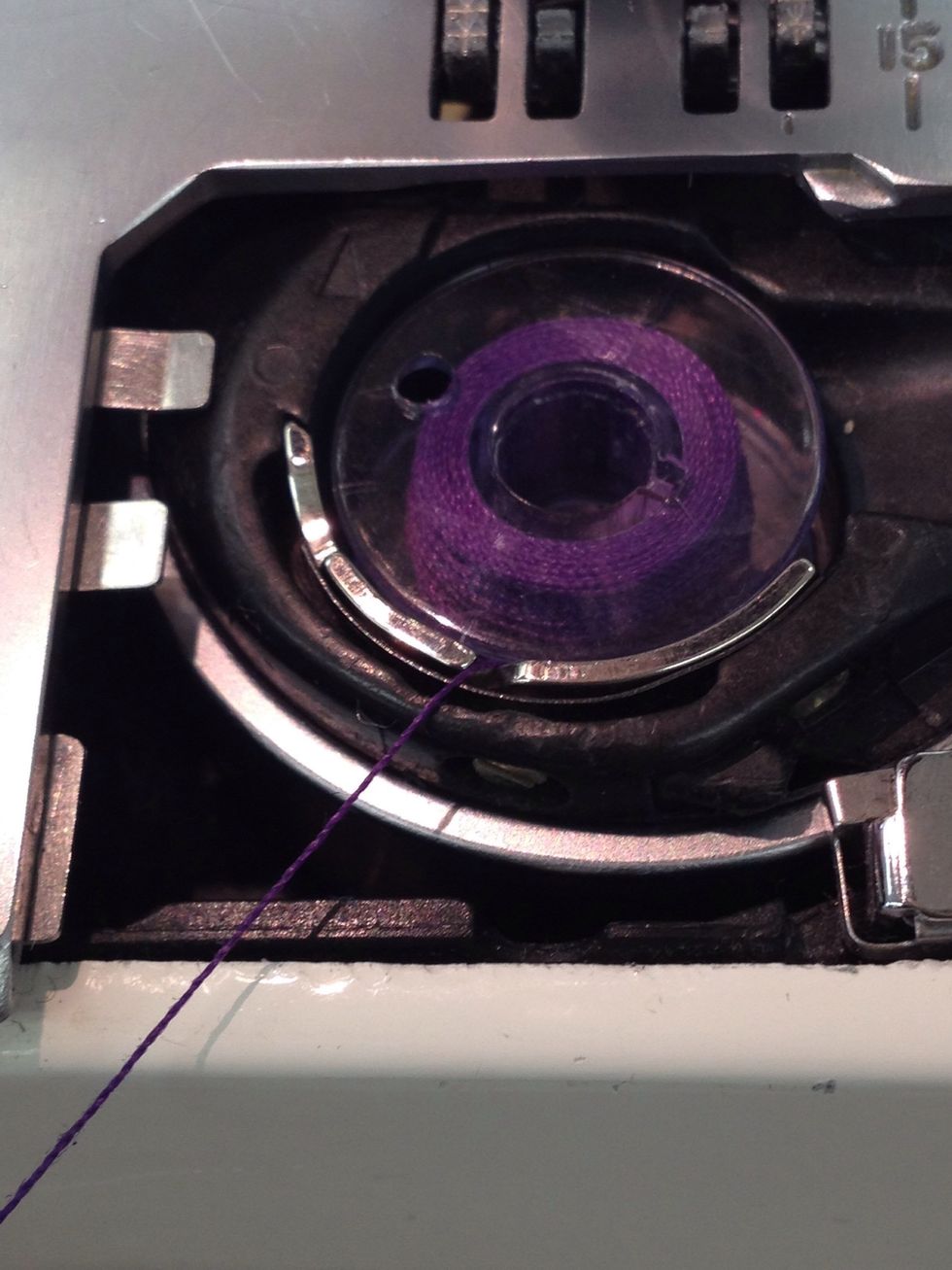 Pull the thread through the first notch.